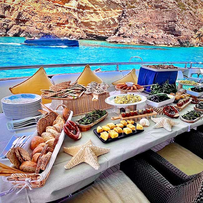 Mesa de catering en un barco con decoración marina y una gran variedad de platos