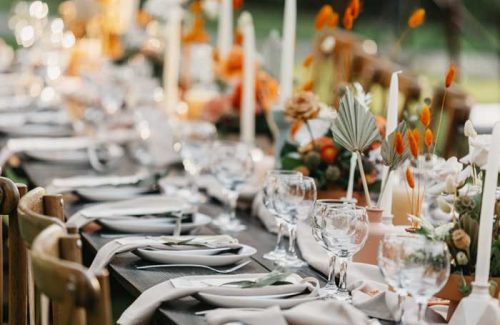 Gran mesa con platos, cubierto y copas decorada par una boda en Ibiza