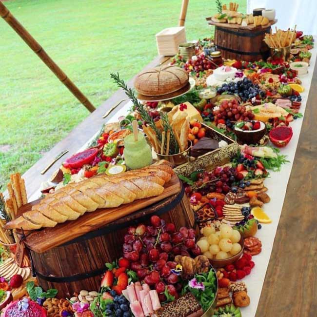 Mesa Grazing con variedad de comida situada en el jardín de una villa